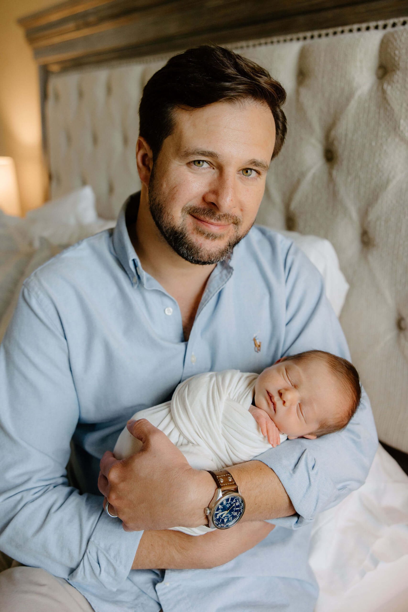 father holding newborn son during lifestyle newborn photography session in family home with East Texas photographer