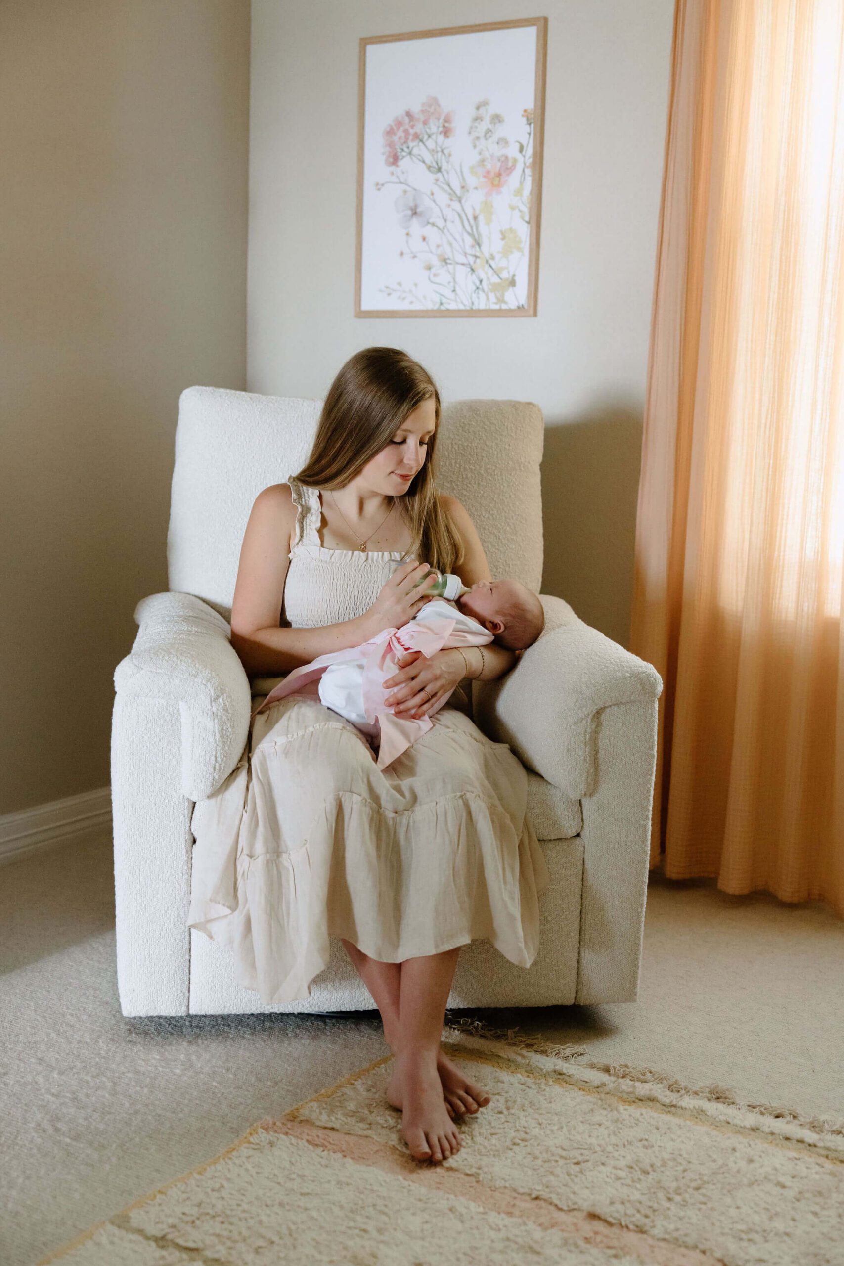 Mother feeding newborn baby in nursery during lifestyle newborn photography session in East Texas