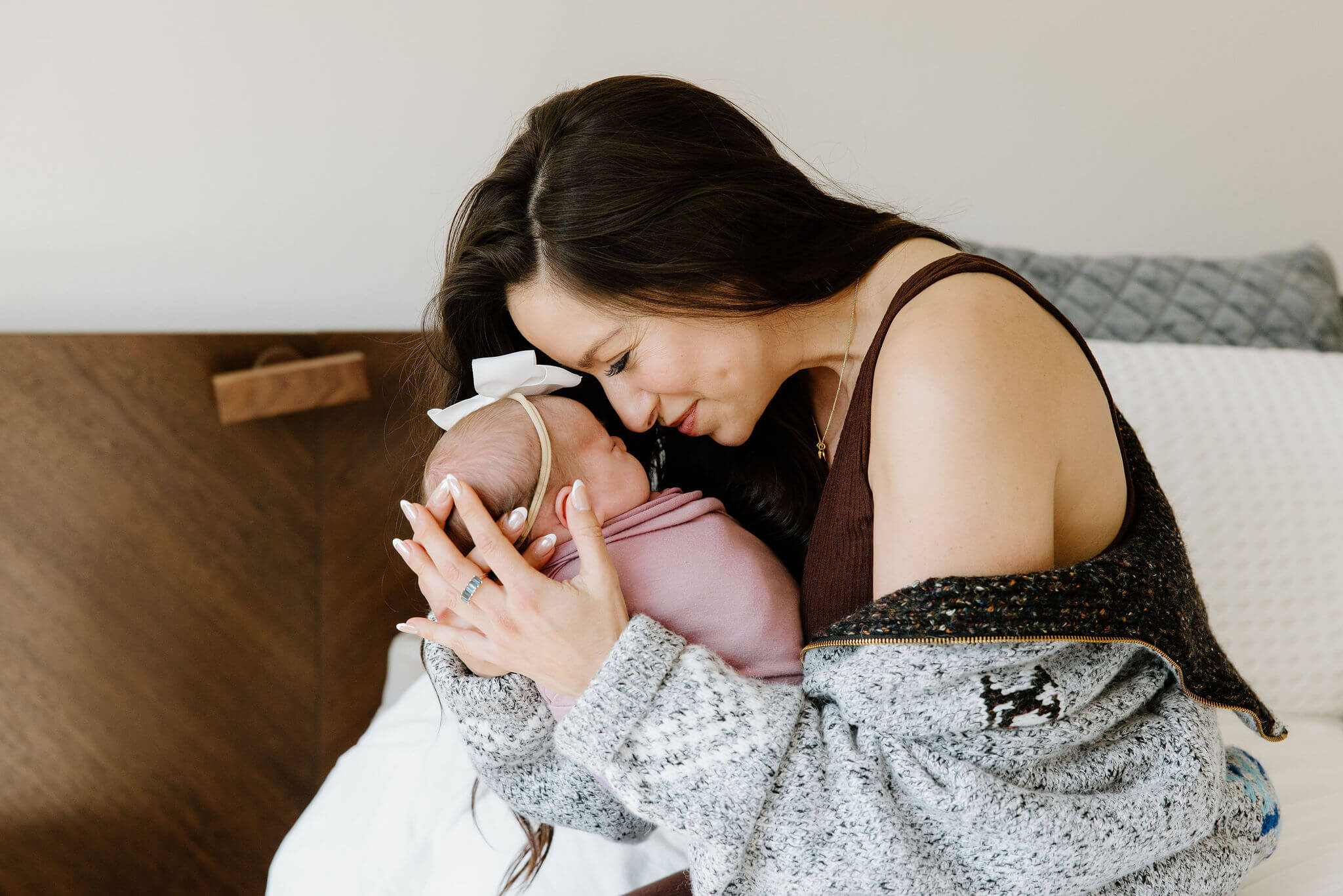 Mother cuddling newborn baby during an in-home lifestyle newborn photography session in Longview, Texas